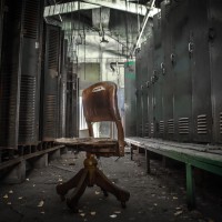 Pull up a Chair - Office chair sits in an abandoned locker room.