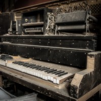 Lost Melody - The school house piano gathers dust as packaging builds up around it.